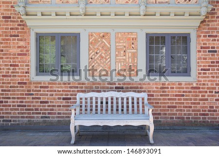 House Bricks Exterior with Windows Frame Stonework Design and Wood Bench on Paver Patio