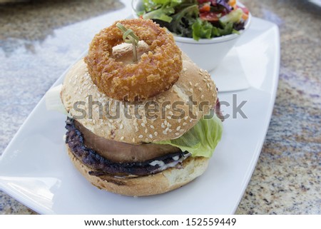Hamburger with Onion Ring Ham Beef Patty Lettuce and Bowl of Organic Green Salad