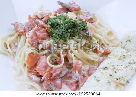 Linguine Pasta and Smoked Salmon Fish Cooked with  Alfredo Sauce Garnished with Parsley and Focaccia Bread Closeup Macro