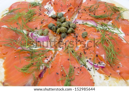Smoked Salmon Pizza Topped with Capers Dill Cream Cheese Onion Tomato and Cracked Peppers Closeup Macro