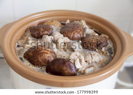 Stewed Shiitake Black Mushrooms and Pork Cooking in Slow Cooker Pot Closeup