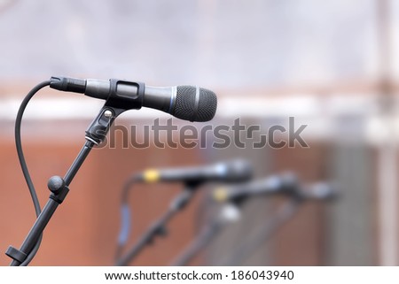 Row of Microphones for Backup Singer on Stage for Live Concert Performance with One Mic in Focus and Others in Blurred Background