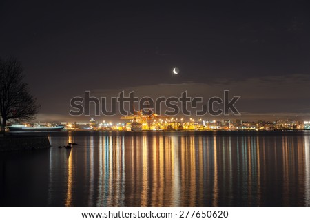 Moonrise Over Port of Vancouver British Columbia Canada at Night with Lights and Water Reflection