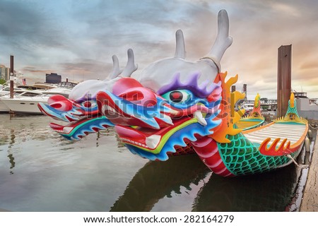 PORTLAND, OREGON - May 25, 2015: Chinese Dragon Boats at Willamette River in Portland OR at Sunset during Rose Festival Dragon Boat Race. It has been a Chinese tradition in Portland for 26 years.