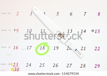Circle marked on a calendar and pregnancy test