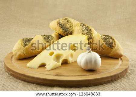 composition with garlic bread and cheese on wooden board