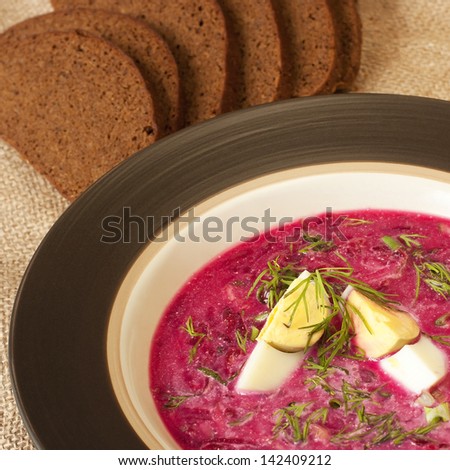 Traditional cold Russian summery soup made of beets, cucumbers and herbs with egg and sour cream
