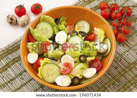 Green salad in  bowl on table. Tomato, cucumber and salad