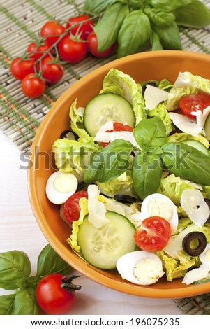 Green salad in  bowl on table. Tomato, cucumber and salad