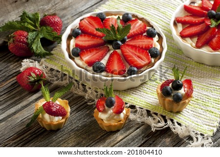 Sweet baskets with cream and strawberries and blueberry