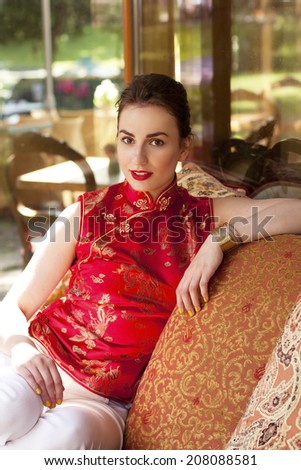 Beautiful girl in red chinese traditional clothes (qipao)