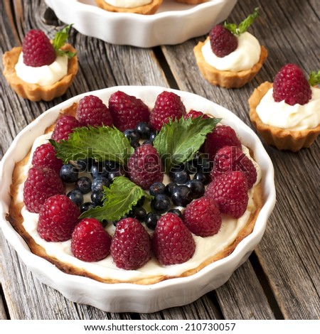 Sweet basket with cream and raspberries and blueberry