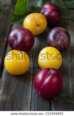 Group of fresh plums on wood background