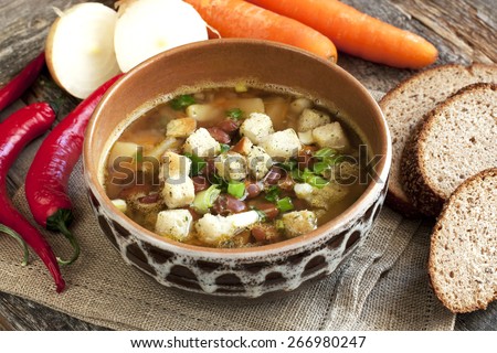 healthy vegetarian bean soup in bowl on old wooden table