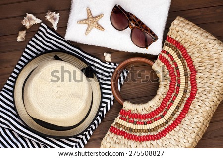 Beach towel, sunglasses and straw hat on wooden background. Concept of vacation, relaxation
