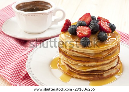 Pancakes with fresh berries and coffee cup