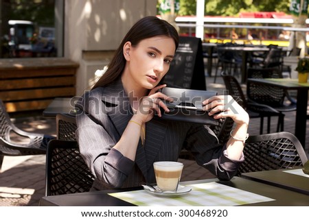 Woman drinking coffee in the morning at street cafe