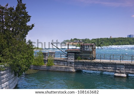 Abandoned and rusted rail crane on bridge at Niagara River just above Horseshoe Falls in Canada