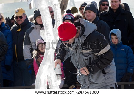 SAINT PAUL, MN/USA - JANUARY 25, 2015: Ice sculptor polishes artwork before competition at St. Paul Winter Carnival. It is the nation\'s oldest winter festival attracting over 250,000 visitors a year.