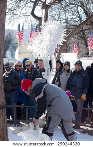 SAINT PAUL, MN/USA  JANUARY 25, 2015: Ice sculptor carves artwork during competition at St. Paul Winter Carnival. It is the nation\'s oldest winter festival attracting over 250,000 visitors a year.