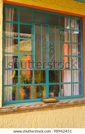 Colorful window reflections of objects on patio at Mexican home