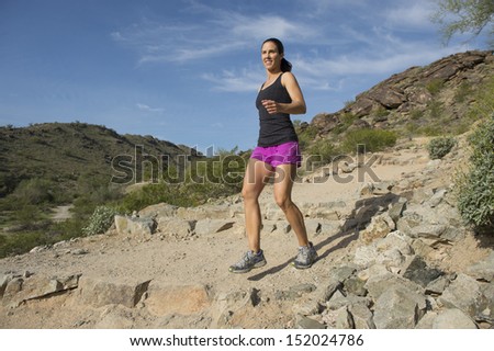 Young woman trail running outdoors at South Mountain Park in Phoenix, Arizona.