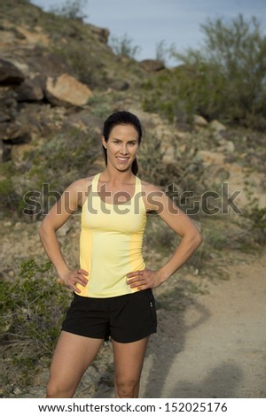 Young woman posing for the camera before her trail run outdoors at South Mountain Park in Phoenix, Arizona.