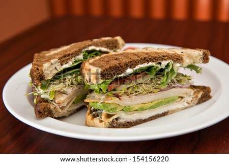 A deli classic turkey sandwich with avocado on rye bread.