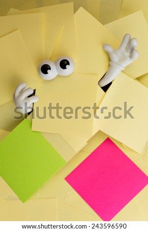 Hands reach out and eyes peer out from under several bright yellow sticky notes as well as a green and pink.
