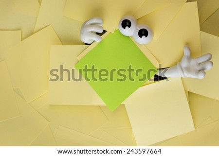 Hands reach out and eyes peer out from under several bright yellow sticky notes and a green one as well.