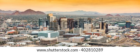 Panoramic aerial view of the Phoenix, Arizona skyline against the day\'s blue sky.