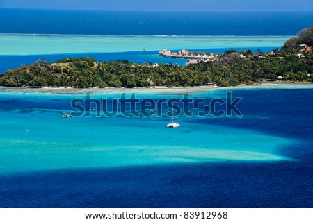 View over beautiful turquoise lagoon of bungalows, island and boats.  Tahiti, Society Islands, French Polynesia.