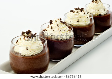 Chocolate Mousse for four topped with whipped cream and dark chocolate shavings.