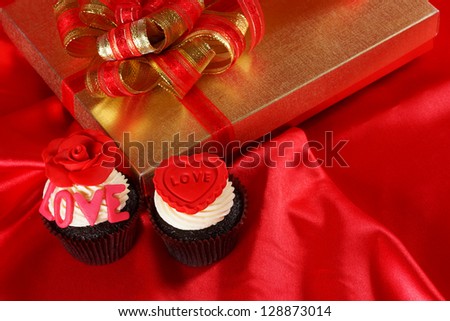 Luxury cupcake with gifts boxes on red satin background