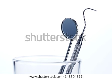 Two Dental Tools in the glass : Dental mirror and probe on white background