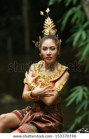 Beautiful Thai lady in Thai traditional drama dress, posing in the forest, greenery in the background, model is Thai Ethnicity.