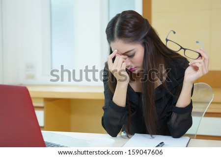 Tired business woman having headache while working at desk