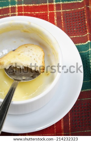 Empty bowl of soup with bread and spoon in the bowl.