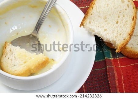 Empty bowl of soup with bread and spoon in the bowl.