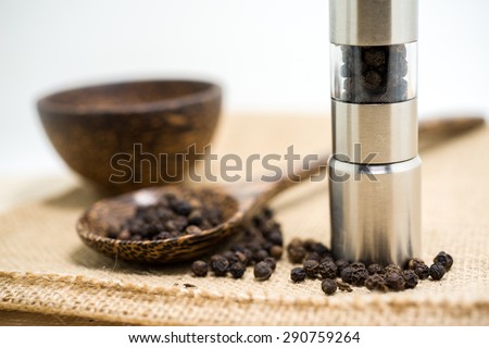 Pepper grinder and black peppercorn.