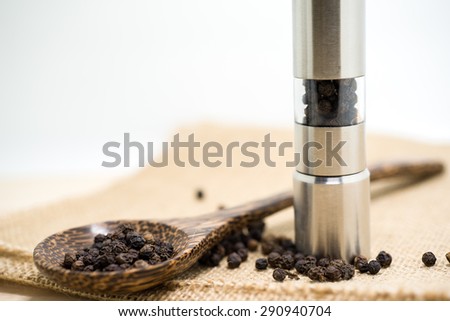 Pepper grinder and black peppercorn.
