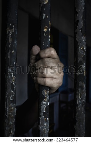 Prisoner hand holding iron bar. add vignette