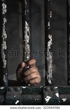Prisoner hand holding iron bar. add vignette
