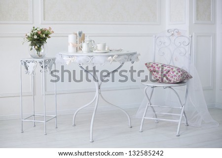 Vintage White Room With Chair And Table With Flowers Pillow, Coffee Cups And Candles