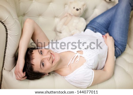 pretty brunette woman on the sofa with teddy bear