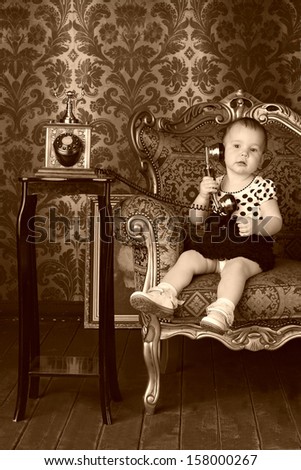 little girl in the retro interior with old telephone
