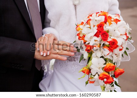 bride and groom hands with flowers