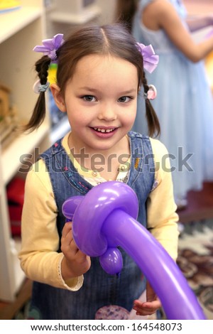 beautiful kinder-garden girl with violet balloon