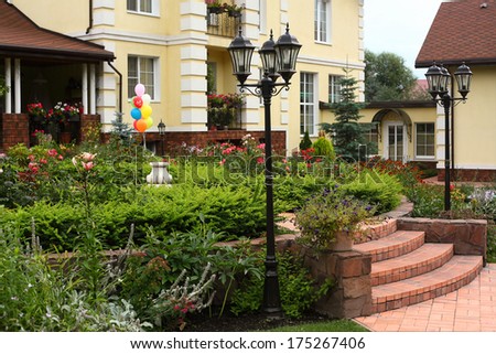 beautiful garden with street lights, birthday balloons and prosperous mansion background