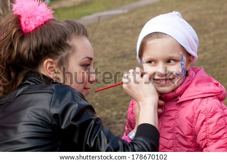 face art process with little blond girl in white hat